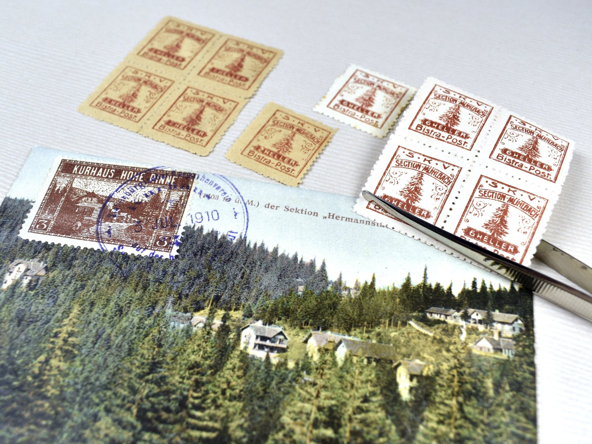 verschiedene Privatpostmarken aus Siebenbürgen und Pinzette