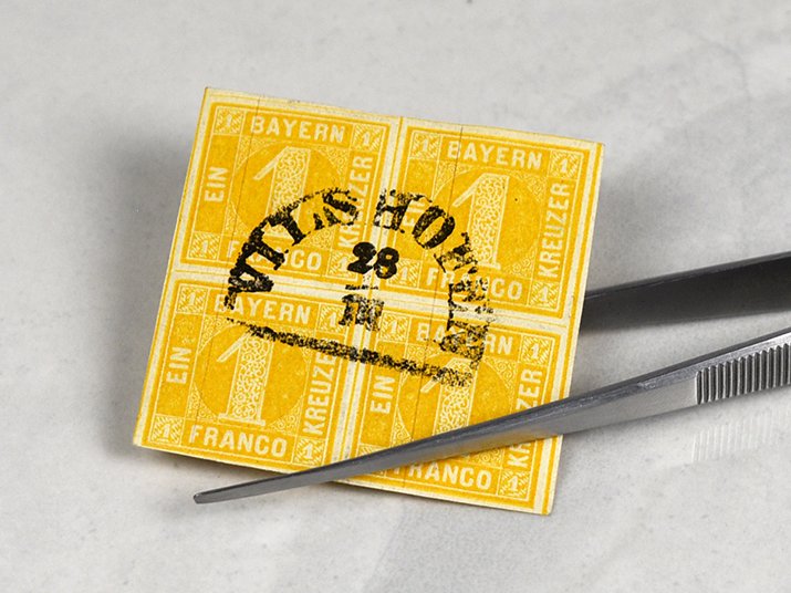 gelbe gestempelte Briefmarke aus Vilshofen, Bayern, mit Pinzette gehalten